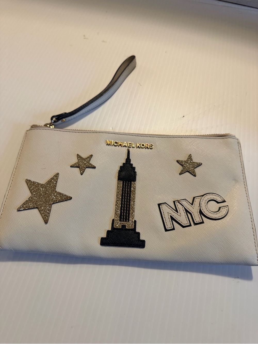 Michael Kors White Wristlet with Gold Logo and Black Empire State Motif